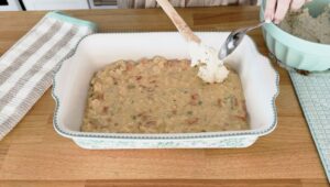 Spooning biscuit mix on top of the casserole
