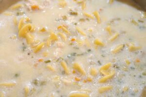 Chicken noodle soup simmering in pan