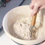 Mixing sourdough ingredients in a large bowl