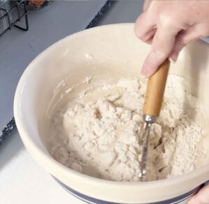 Mixing sourdough ingredients in a large bowl