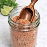 Homemade taco seasoning in a Mason jar with little scoop