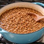Brown Beans made with pinto beans in a blue dutch oven on the stove