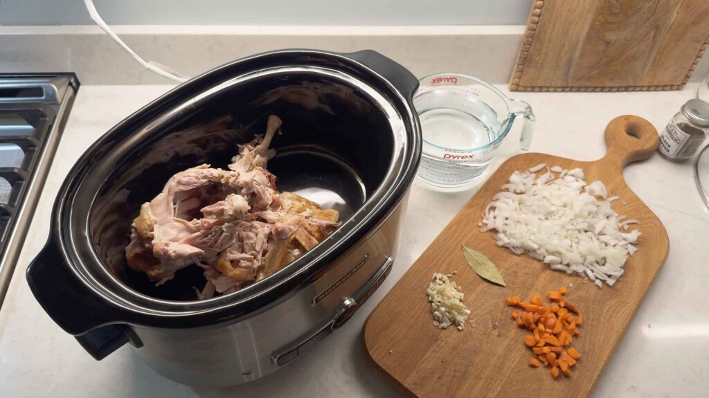 Chicken bones and carcass in a slow cooker