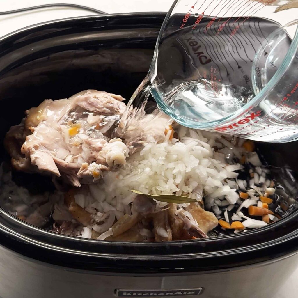 Pouring water on bones and vegetables