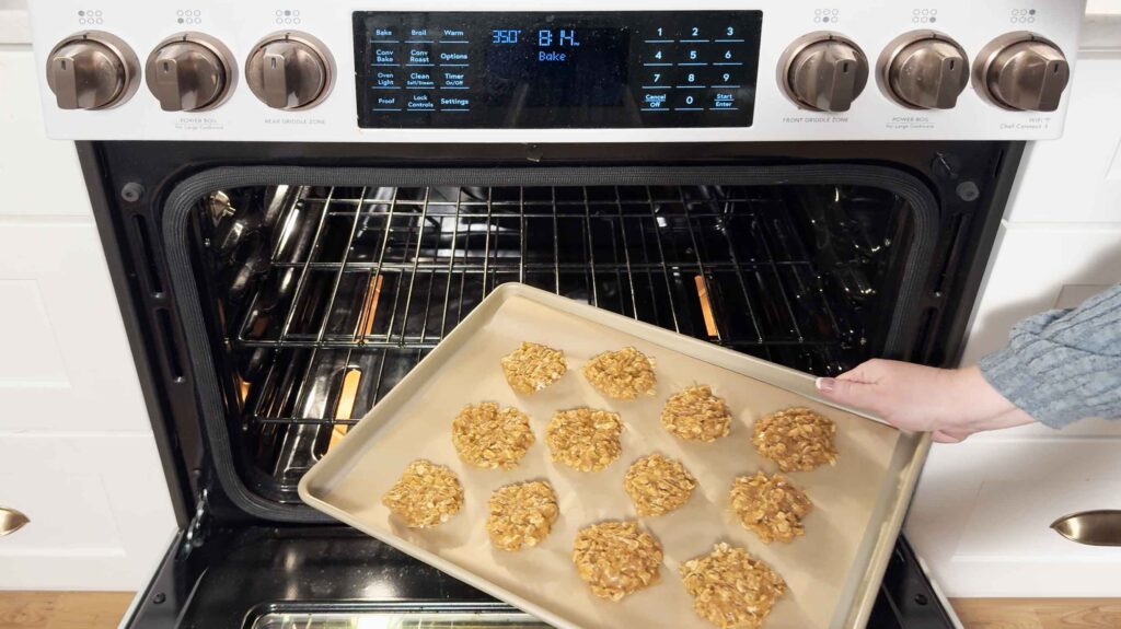 Putting oatmeal peanut butter cookies in the oven