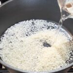 Adding water to rice in pot