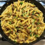 Creamy sausage pasta in a cast-iron-skillet on the stove