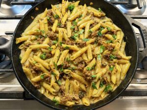 Creamy sausage pasta in a cast-iron-skillet on the stove