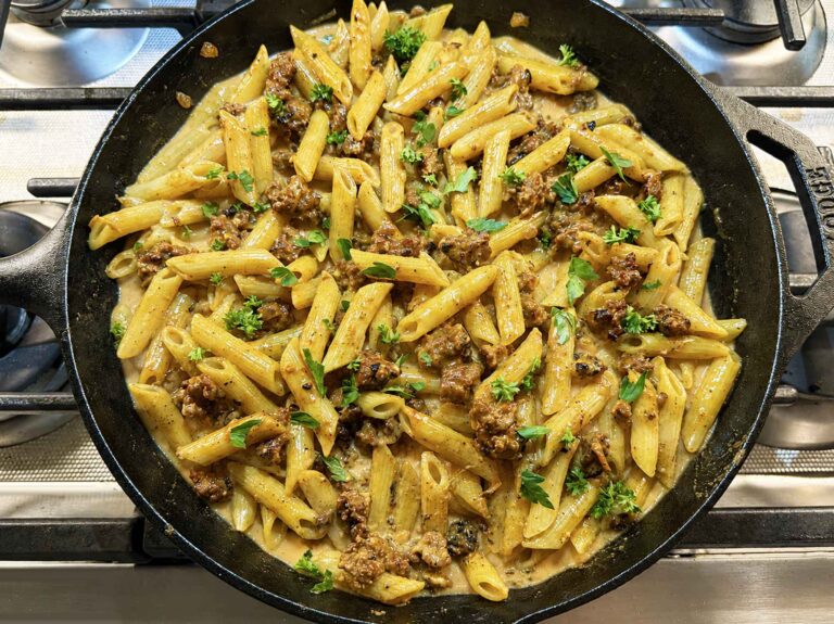 Creamy sausage pasta in a cast-iron-skillet on the stove