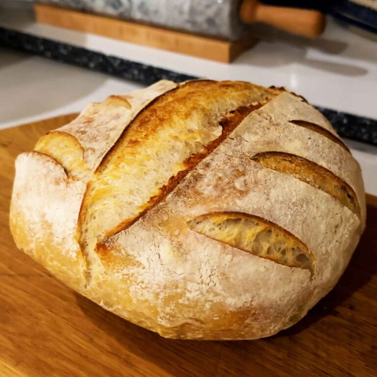 A round loaf of sourdough bread on a cutting board