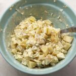 Folding in potatoes to make the salad