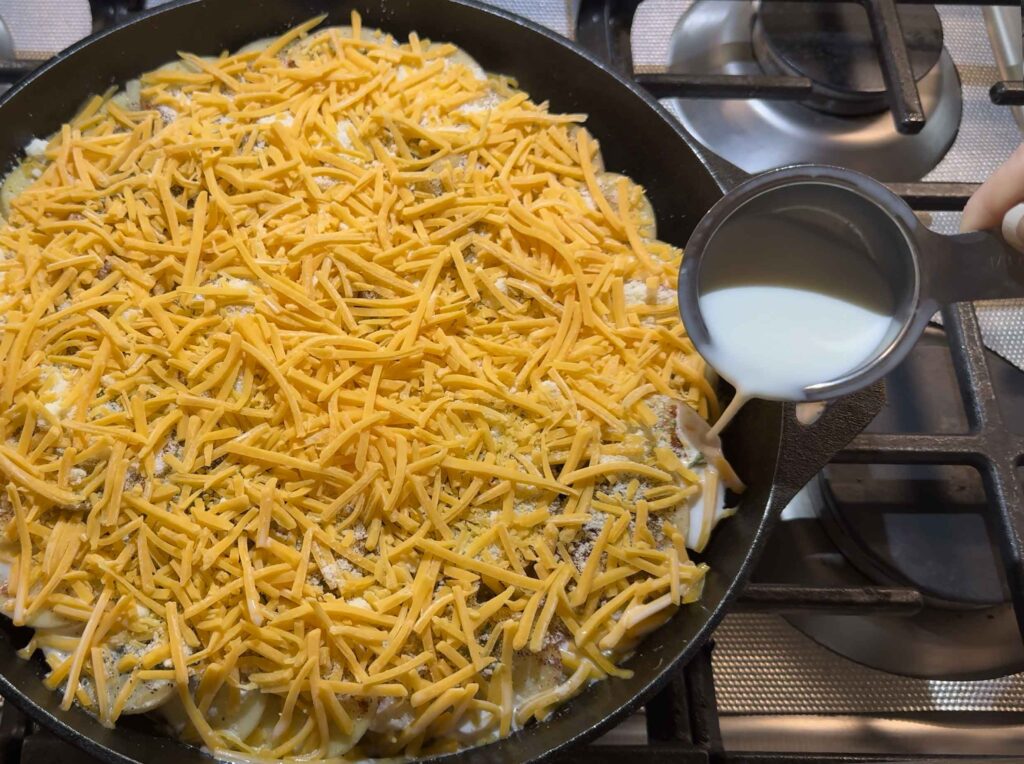 pouring milk along the side of the casserole