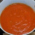 Tomato sauce simmering in enchilada sauce in pan