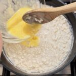 Stirring tempered egg into pudding
