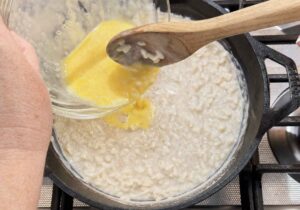 Stirring tempered egg into pudding