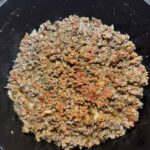 Tomato paste mixed in with ground beef and onions and garlic