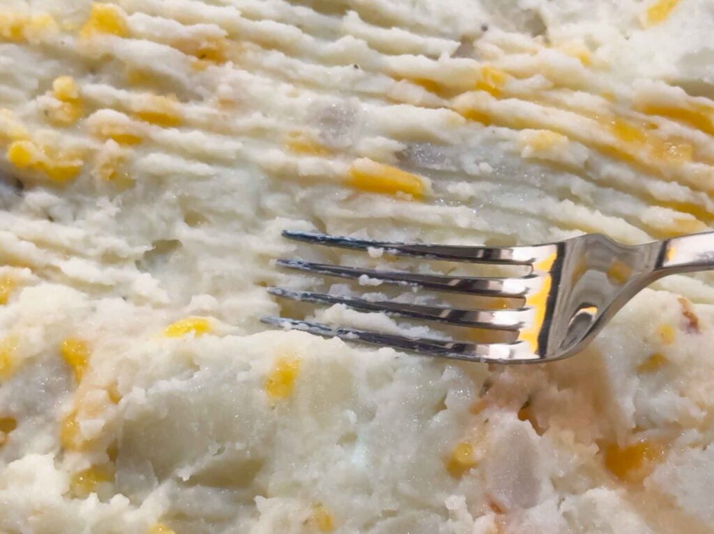 Using a fork to make ridges in shepherds pie mashed potatoes