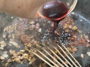 Adding red wine to skillet