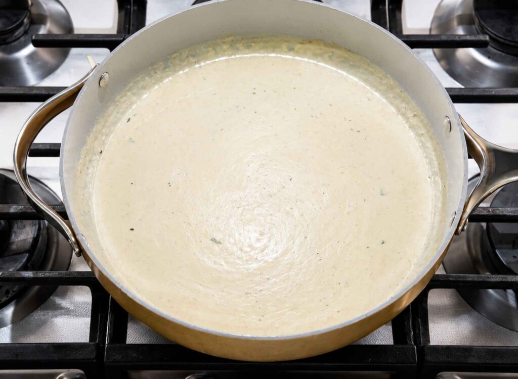 A skillet of fresh, creamy, and smooth Alfredo sauce