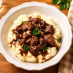 Beef tips and gravy over mashed potatoes in a bowl on our dinner table