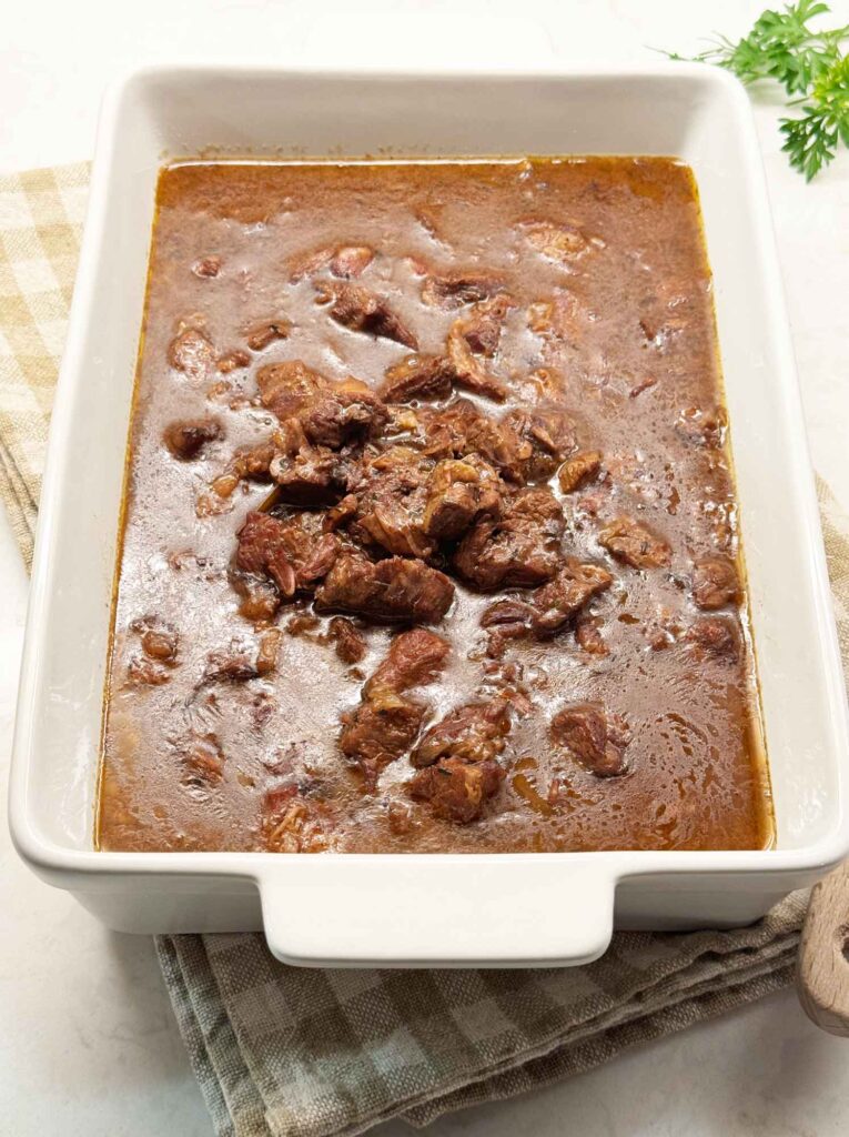 Beef tips and gravy with a skin of fat forming on the surface