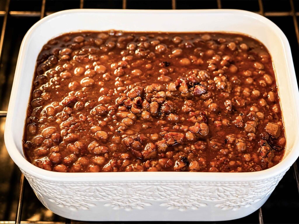 A baking dish filled with baked beans in the oven