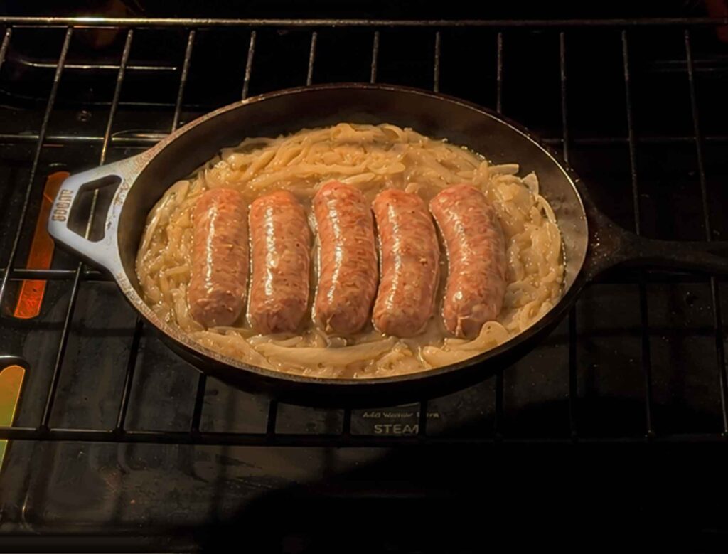 Bratwurst cooking in skillet in oven