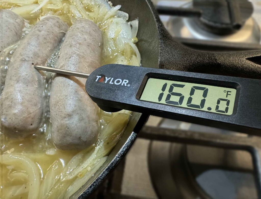 Taking the internal temperature of bratwurst with an instant read thermometer