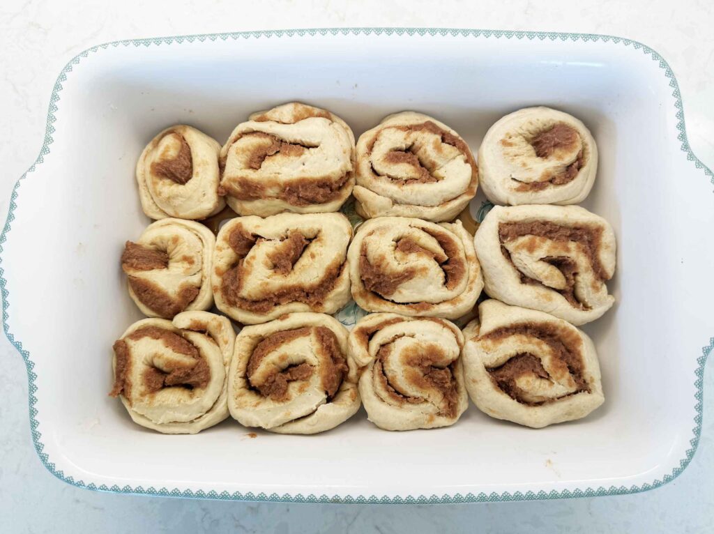 Cut cinnamon rolls in a greased baking dish right after being in refrigerator overnight