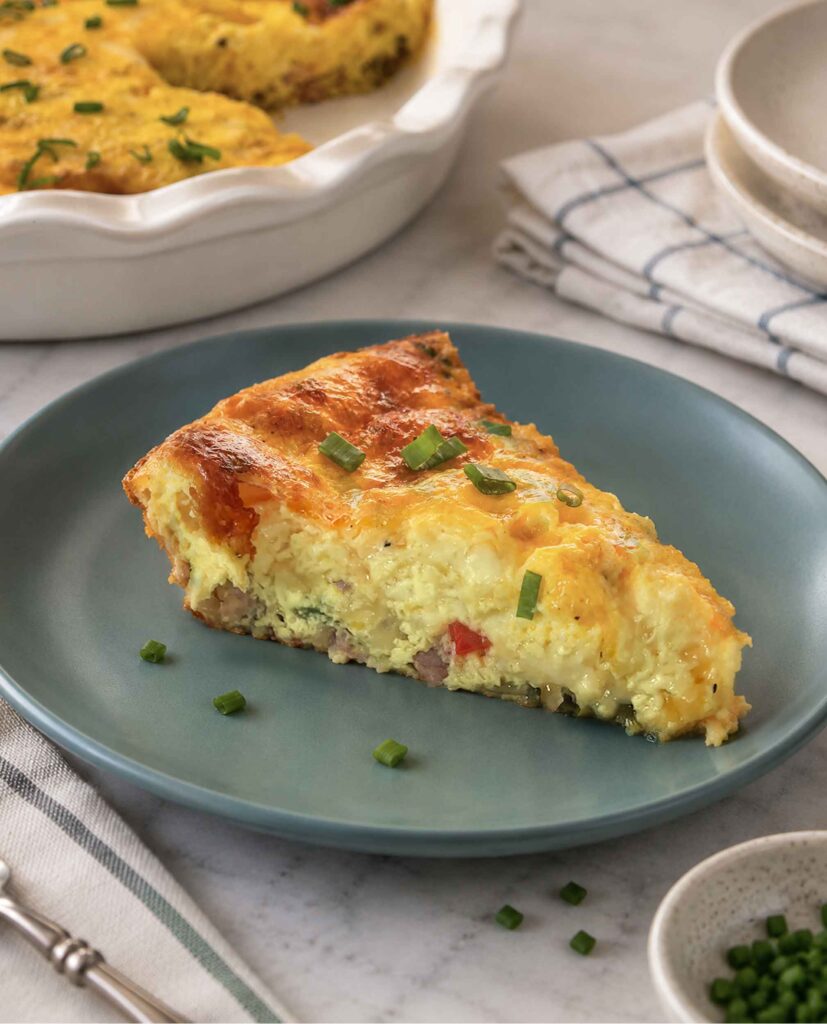 A slice of crustless quiche on a blue plate