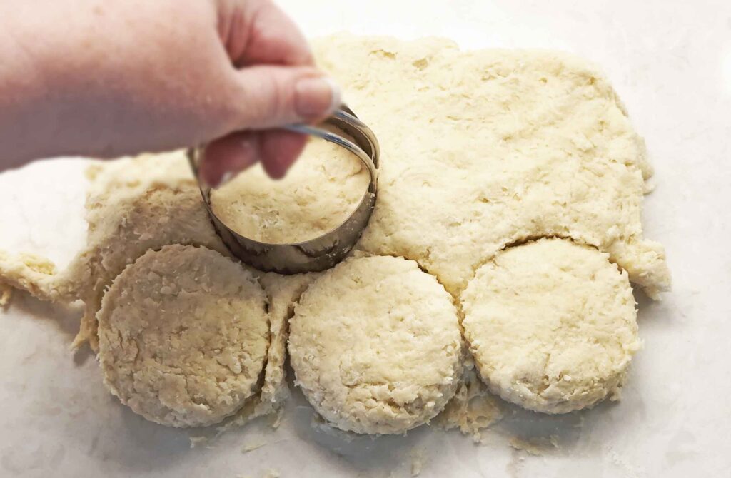 Cutting out sourdough discard biscuits with a sharp biscuit cutter