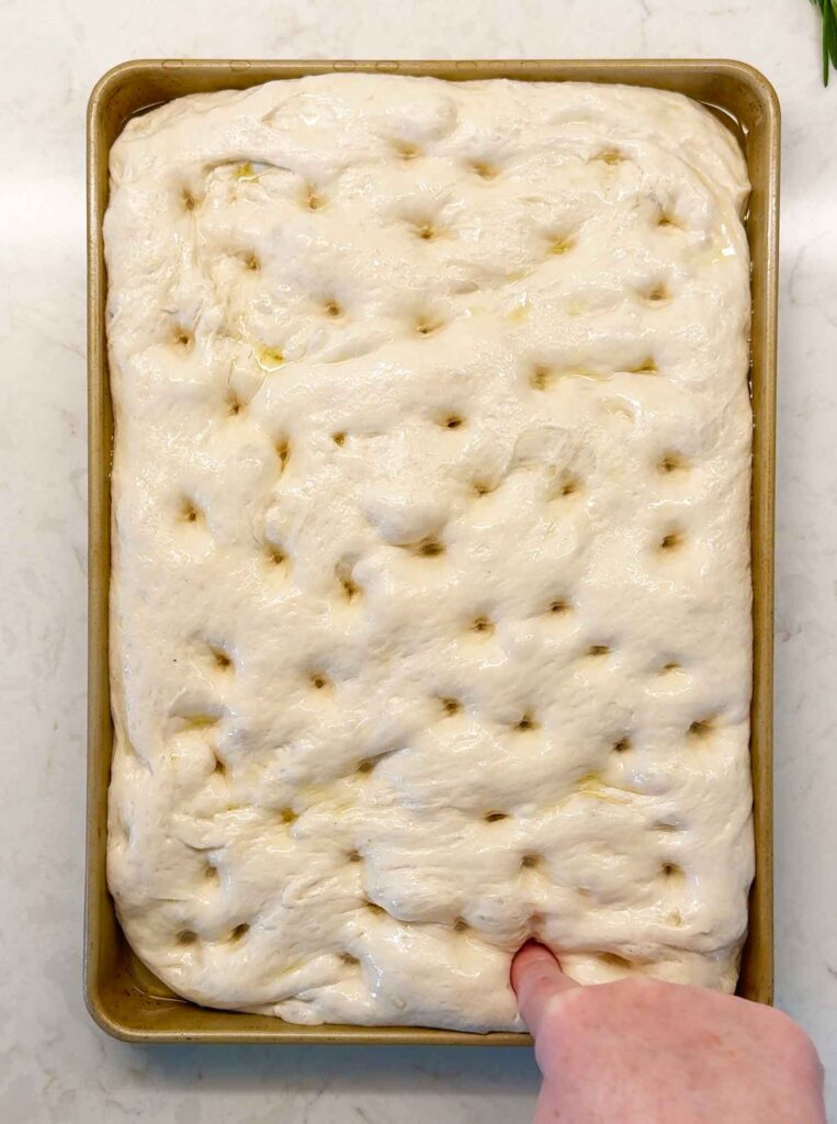 Dimpling the top of the sourdough focaccia bread