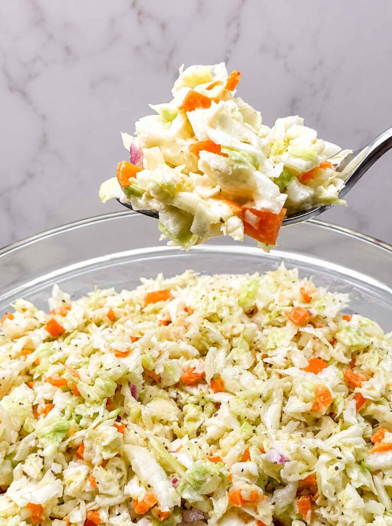 Coleslaw on a fork over a bowl