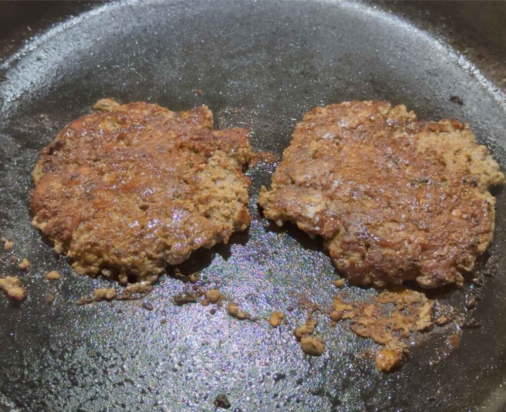 Two smash burgers in a cast iron skillet