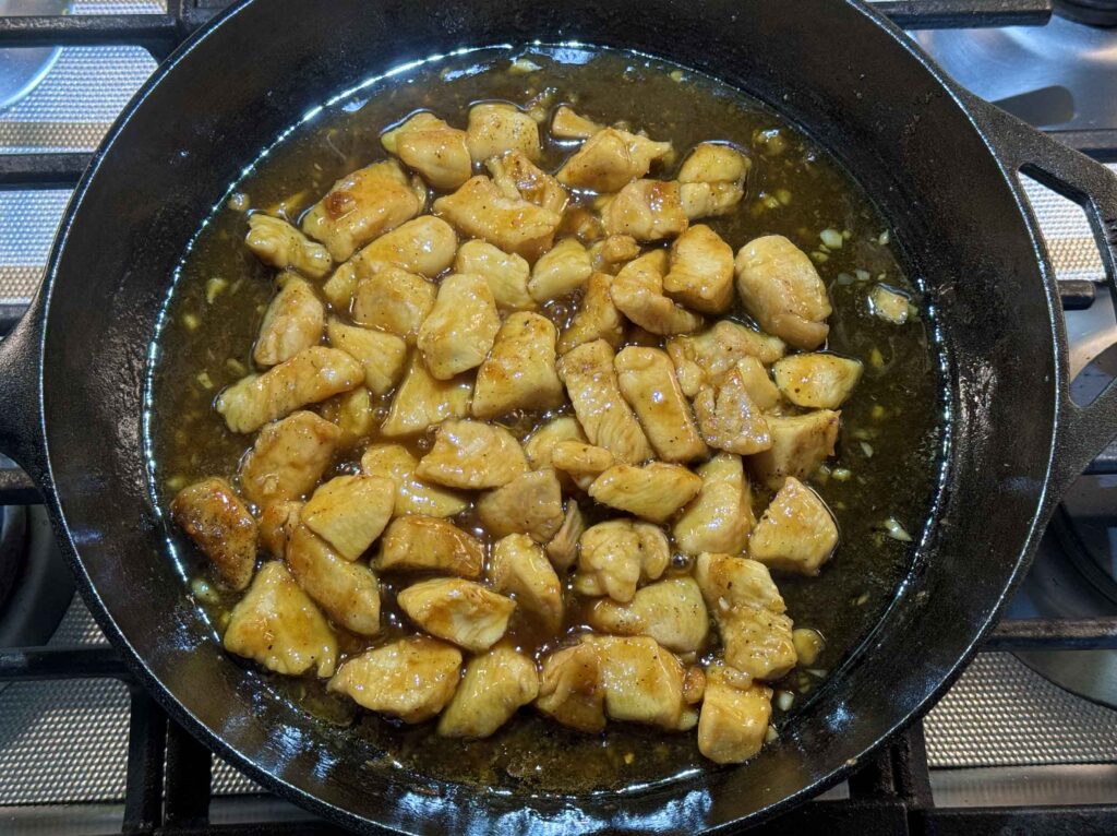 Honey-garlic chicken simmering in skillet