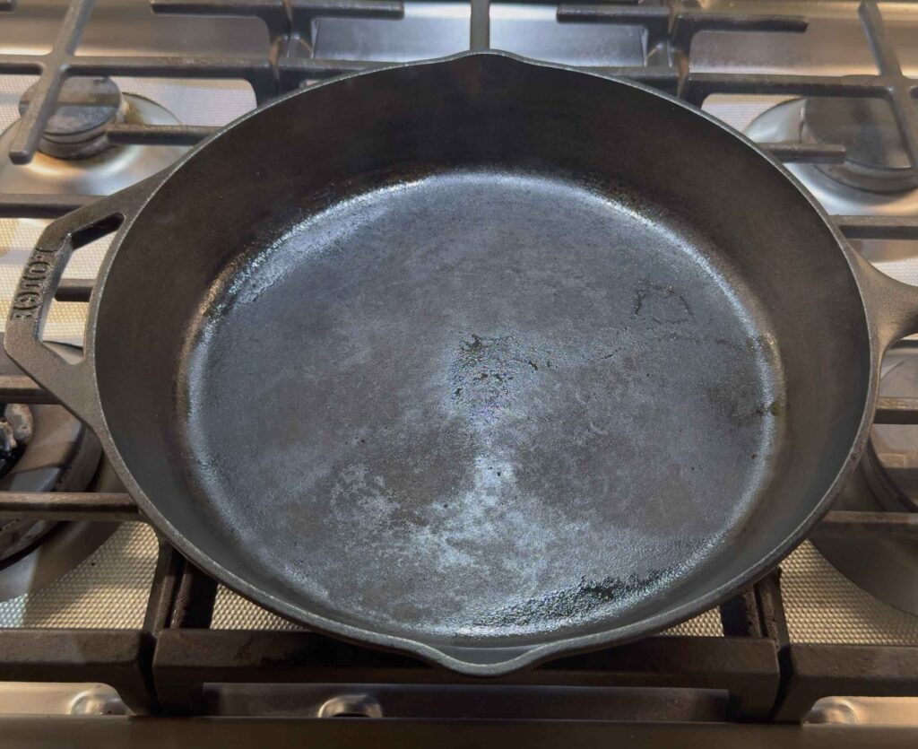 Heating the cast iron skillet for smash burgers