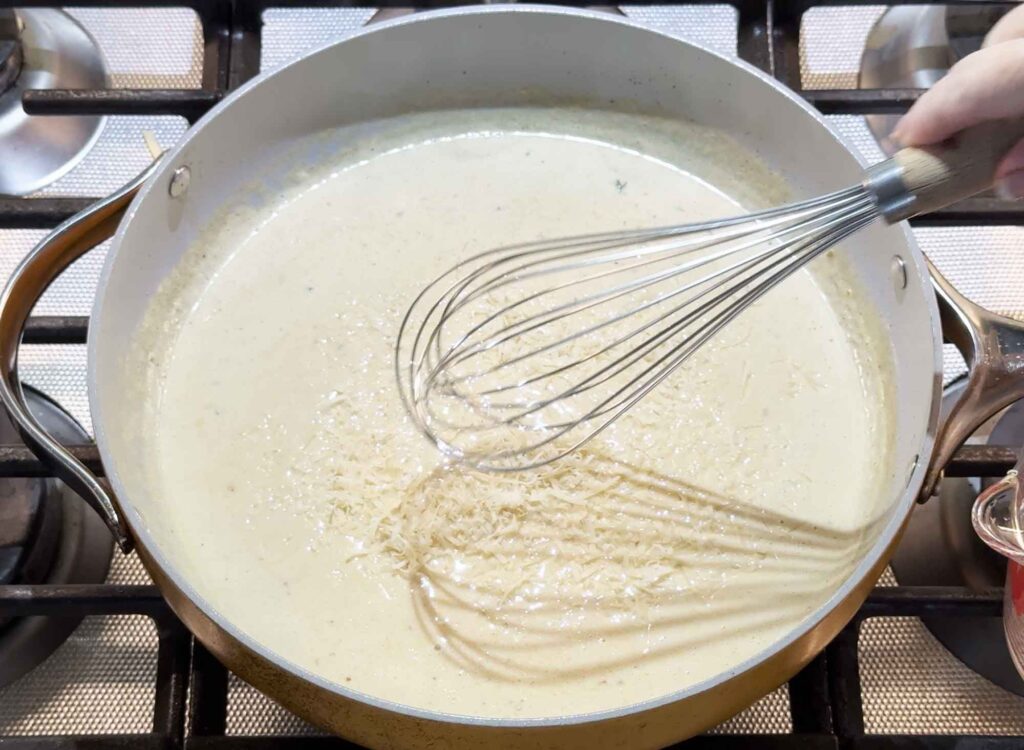Mixing the Parmesan cheese into the alfredo sauce
