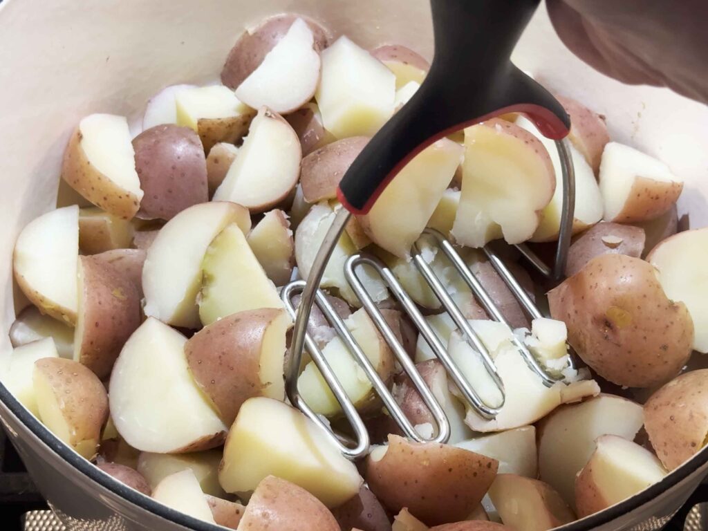 Mashing potatoes in a pot