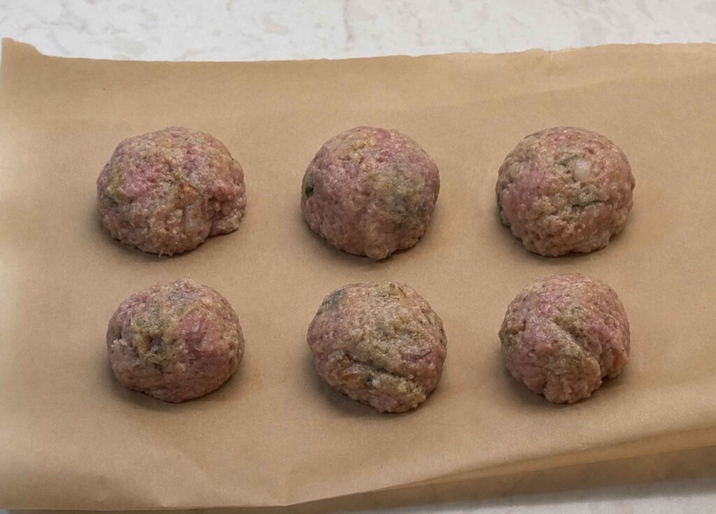 Same size turkey meatballs on parchment paper