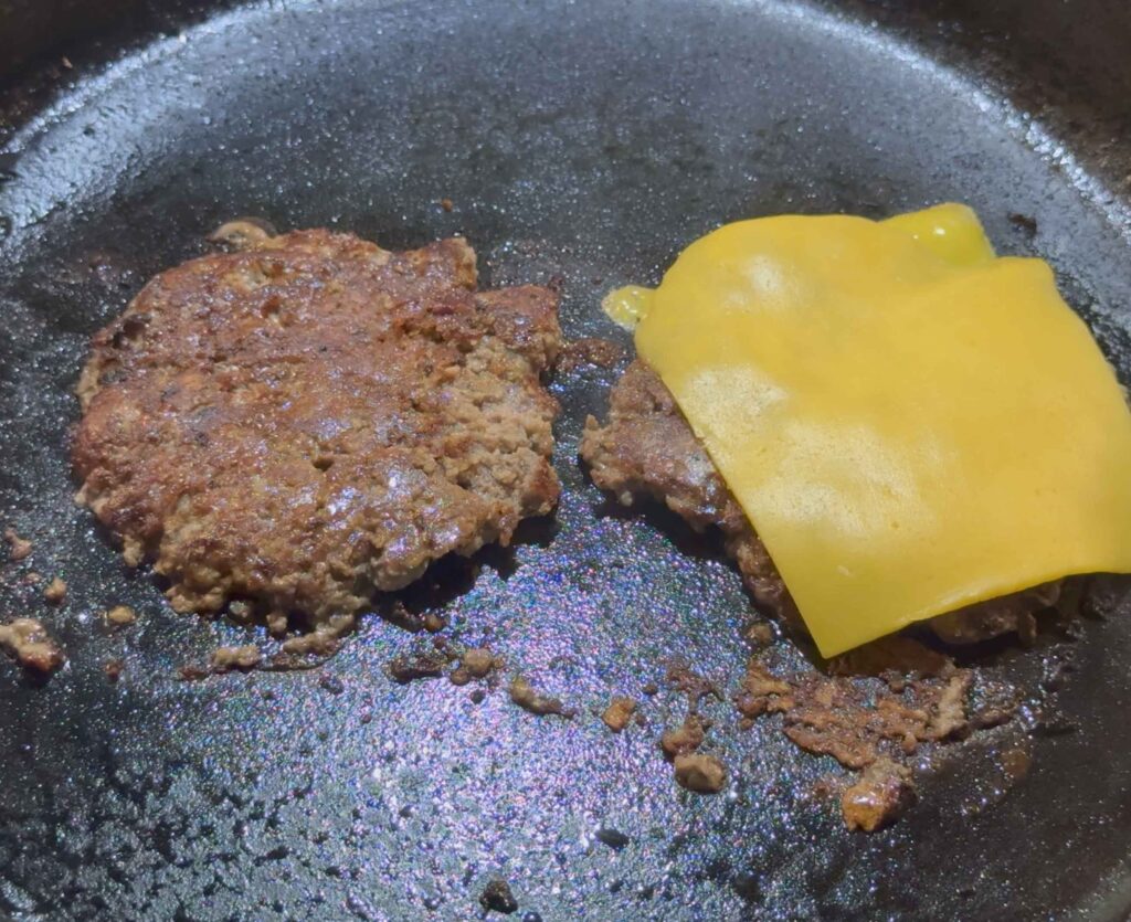 Placing cheese on the smash burgers
