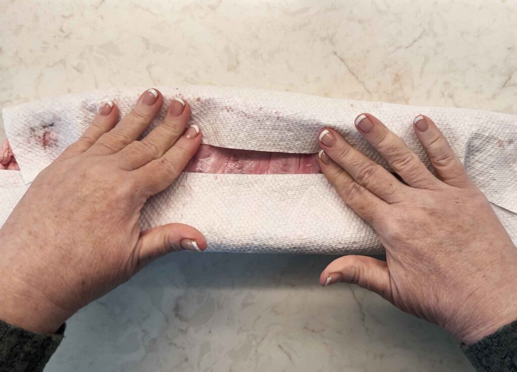 Patting the ribs dry with a paper towel