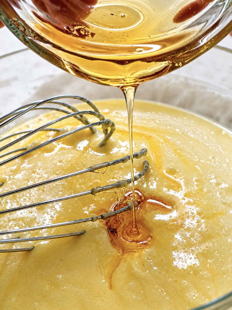 Pouring honey into wet ingredients for the cornbread recipe