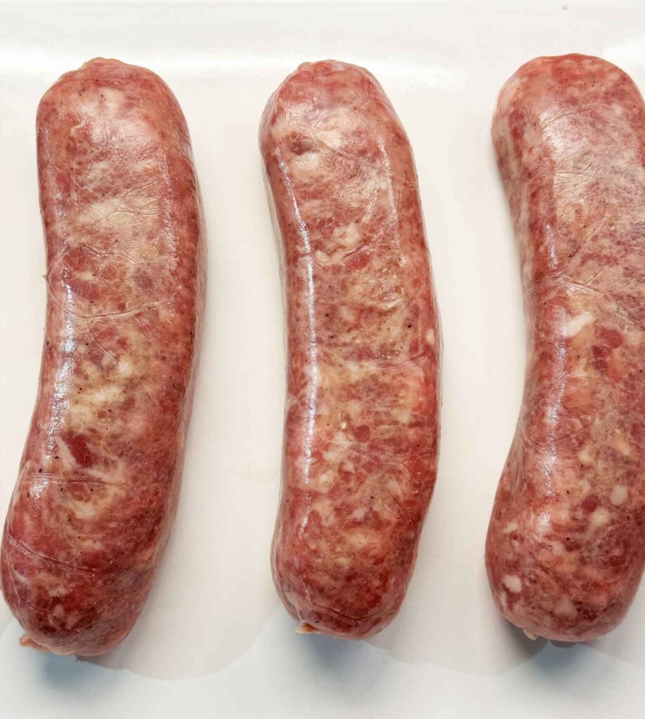 Three raw and uncooked bratwurst sausages