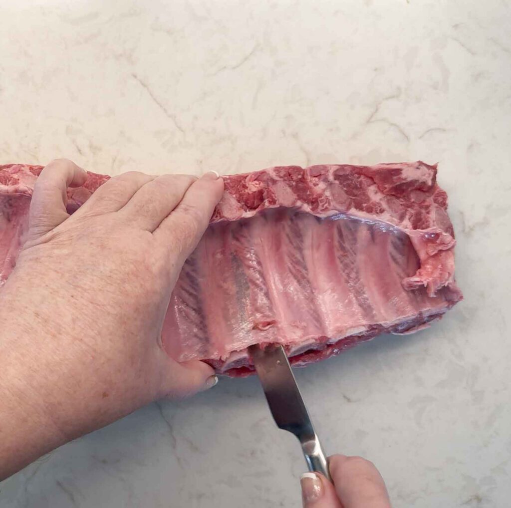 Sliding a knife under the membrane of the ribs