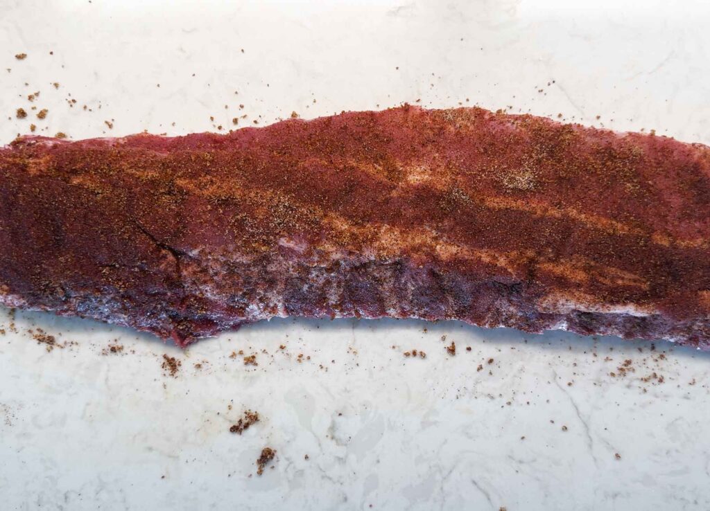 Seasoning the ribs with the rub
