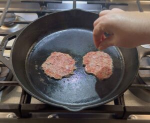 Seasoning the smash burgers.