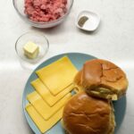 Bowl of ground meat, butter, salt, pepper, American cheese, and brioche buns ready to make smash burgers