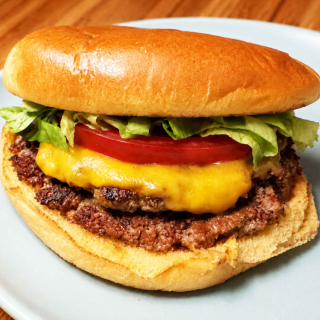 Smash burger with cheese, lettuce, and tomato on a toasted bun