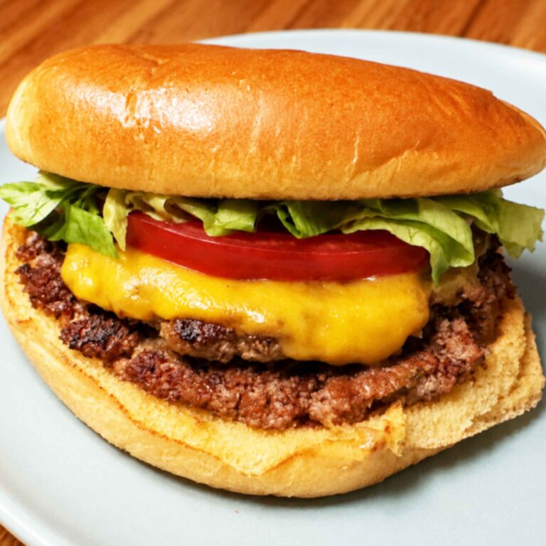 Smash burger with cheese, lettuce, and tomato on a toasted bun