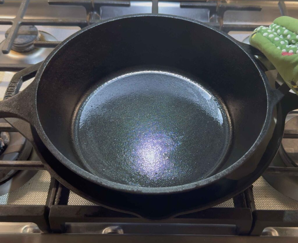 Pressing on the burgers with another cast iron pan